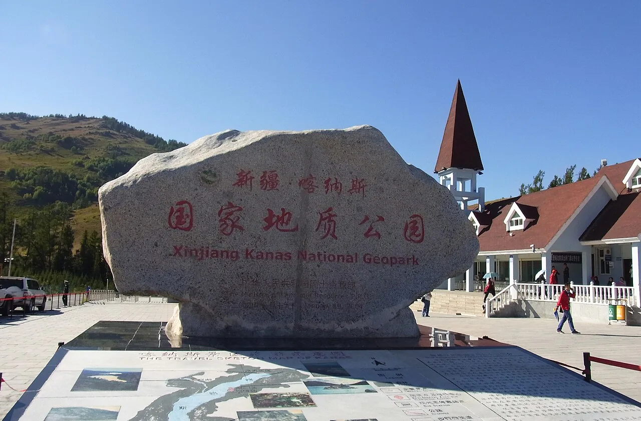 喀纳斯国家地质公园入口石刻与山林，游客从入口经过